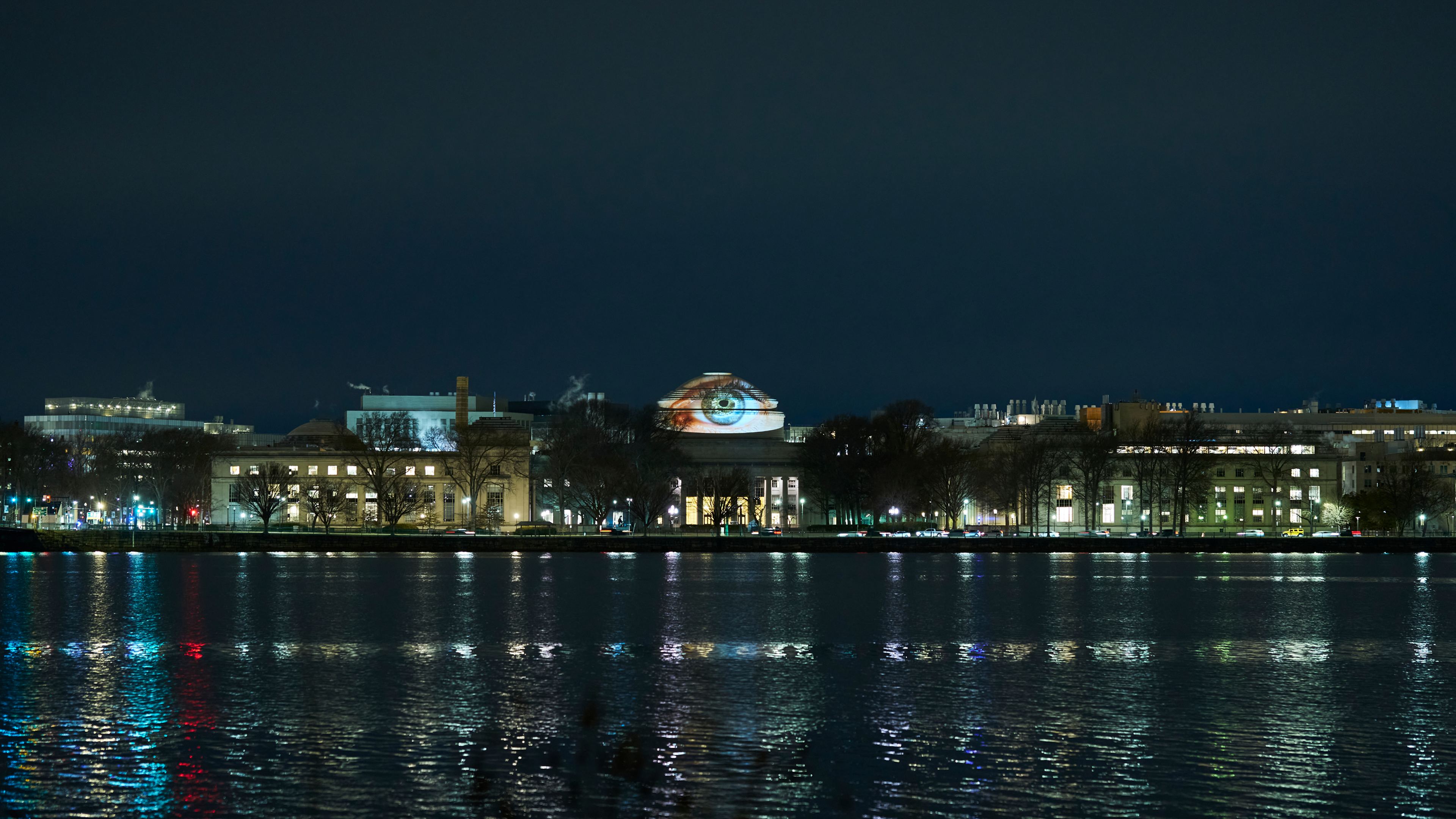 MIT’s Great Dome at night, its projection reflected across the Charles River